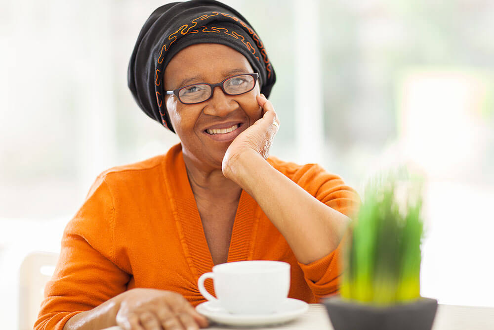Smiling woman sitting at table with a coffee mug in front of her